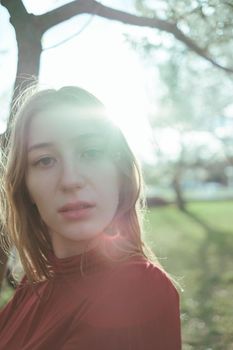 portrait of a girl in backlight in the park in the spring close-up