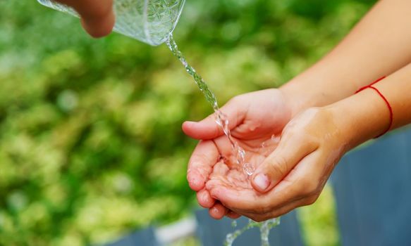 The child washes his hands in the street. Selective focus. nature