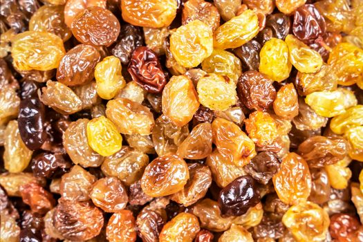 background of delicious sweet yellow raisins on the table close-up. dried grapes. golden organic raisins. textured food background