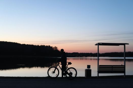 Silhouette of a cyclist on the beach at sunset.