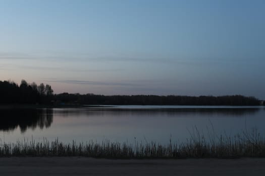 sunset at coast of the lake. Nature landscape. Reflection, blue sky and yellow sunlight. landscape during sunset.