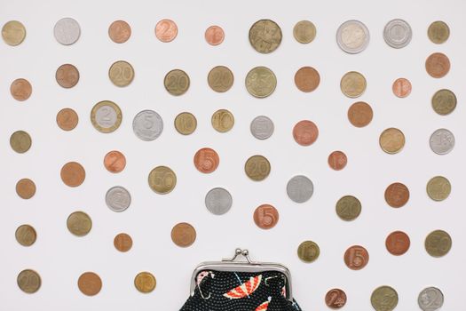 Open purse with different coins isolated on white background top view. Financial crisis, poverty, lack of money