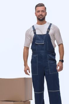 in full growth. smiling man standing near cardboard boxes. photo with copy space