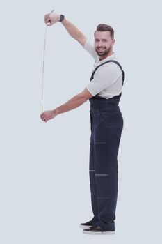 in full growth. smiling man showing construction - roulette. isolated on white background