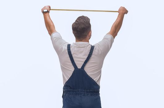 rear view. a man measuring something with a construction tape measure. isolated on white background