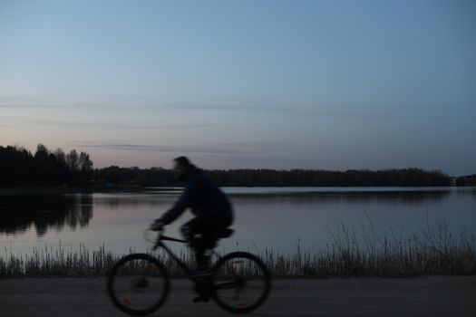Silhouette of a cyclist on the beach at sunset.