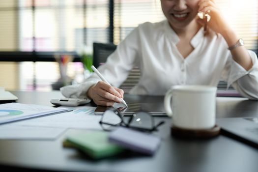 Close up business woman hand holding stylus pen and digital tablet for planning working schedule in office.