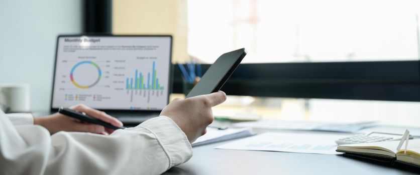 Close up business woman using mobile phone for financial accounting concept