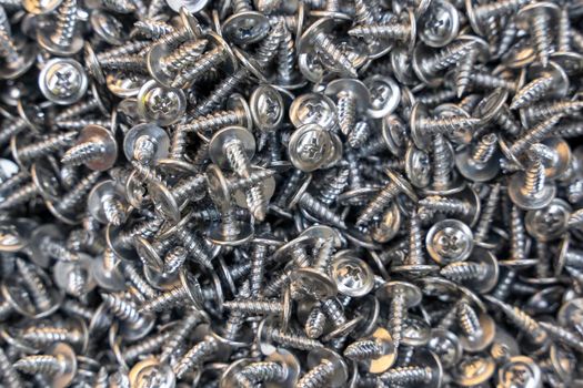 A lot of metal galvanized self-tapping screws. Industrial texture background of self-tapping screws.