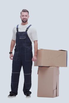 in full growth. smiling man standing near cardboard boxes. photo with copy space