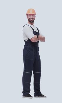 in full growth. smiling man in overalls and a safety helmet . isolated on white background