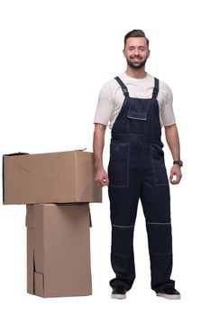 in full growth. smiling man standing near cardboard boxes. photo with copy space