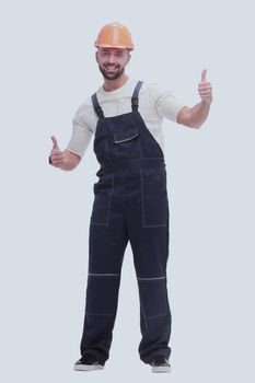 in full growth. smiling man in overalls showing thumbs up . isolated on white background