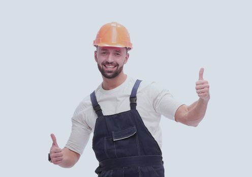 in full growth. smiling man in overalls showing thumbs up . isolated on white background