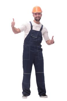 in full growth. smiling man in overalls showing thumbs up . isolated on white background