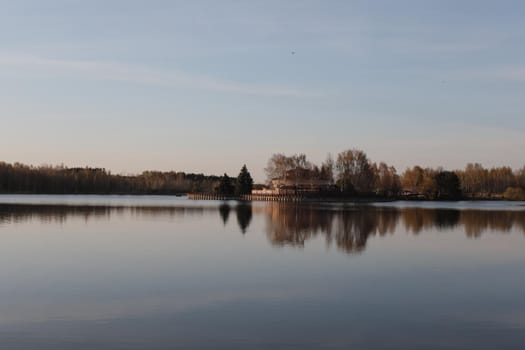 sunset at coast of the lake. Nature landscape. Reflection, blue sky and yellow sunlight. landscape during sunset.