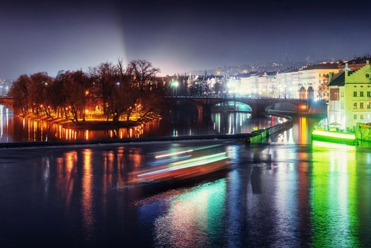 Scenic view of bridges on the Vltava river and of the historical center of Prague: buildings and landmarks of old town with red rooftops.