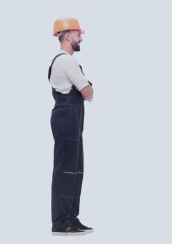 in full growth. smiling man in overalls and a safety helmet . isolated on white background