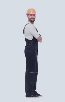 in full growth. smiling man in overalls and a safety helmet . isolated on white background