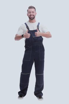 in full growth. friendly man in overalls showing thumbs up. isolated on white background