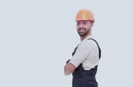 in full growth. smiling man in overalls and a safety helmet . isolated on white background