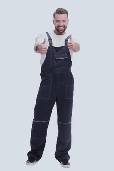 in full growth. friendly man in overalls showing thumbs up. isolated on white background