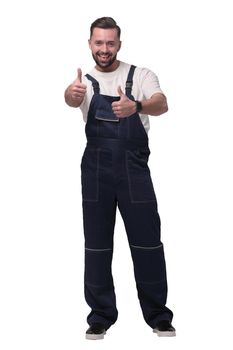 in full growth. friendly man in overalls showing thumbs up. isolated on white background