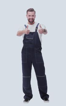 in full growth. friendly man in overalls showing thumbs up. isolated on white background