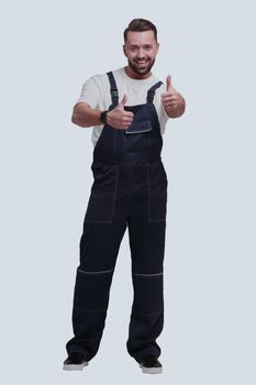 in full growth. friendly man in overalls showing thumbs up. isolated on white background