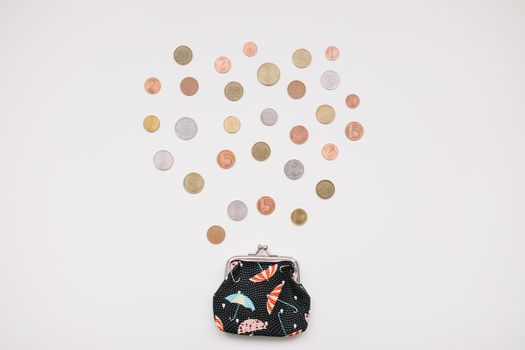 Open purse with different coins isolated on white background top view. Financial crisis, poverty, lack of money