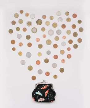 Open purse with different coins isolated on white background top view. Financial crisis, poverty, lack of money