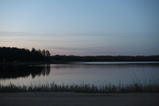 sunset at coast of the lake. Nature landscape. Reflection, blue sky and yellow sunlight. landscape during sunset.