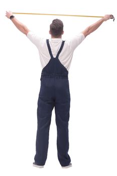 rear view. a man measuring something with a construction tape measure. isolated on white background