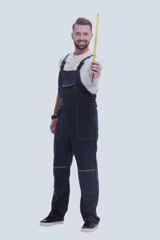 in full growth. a man in overalls with a construction tape measure. isolated on white background