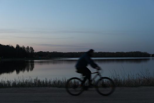 Silhouette of a cyclist on the beach at sunset.