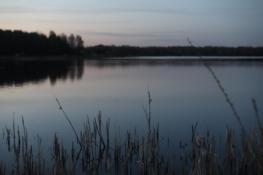 sunset at coast of the lake. Nature landscape. Reflection, blue sky and yellow sunlight. landscape during sunset.
