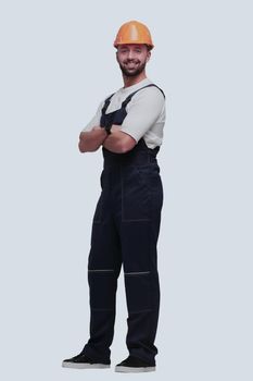 in full growth. smiling man in overalls and a safety helmet . isolated on white background