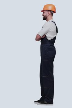 in full growth. smiling man in overalls and a safety helmet . isolated on white background