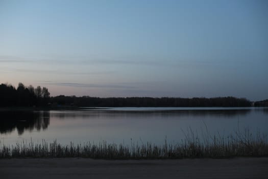sunset at coast of the lake. Nature landscape. Reflection, blue sky and yellow sunlight. landscape during sunset.