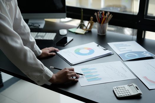 Business woman using calculator for do math finance on wooden desk in office and business working background, tax, accounting, statistics and analytic research concept.