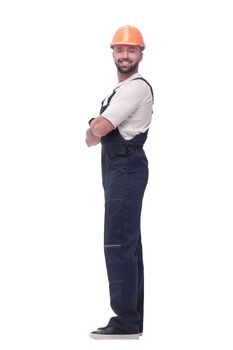 in full growth. smiling man in overalls and a safety helmet . isolated on white background