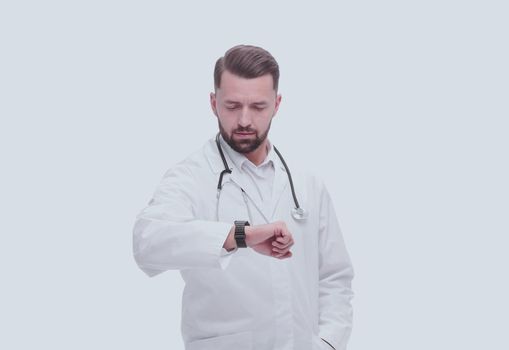 in full growth. medical doctor looking at his wrist watch. isolated on white background