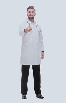 in full growth. smiling medical professional showing thumbs up .isolated on white background