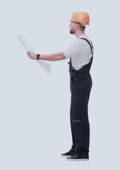 in full growth. competent foreman Builder looking at drawings. isolated on white background