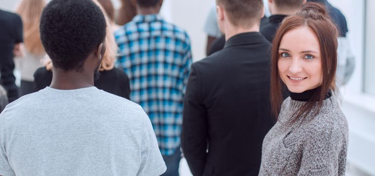 rear view . young woman standing among a group of diverse young people