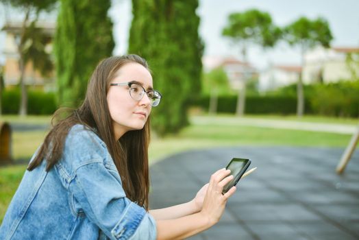 young beautiful student girl is learning outdoor. High quality photo