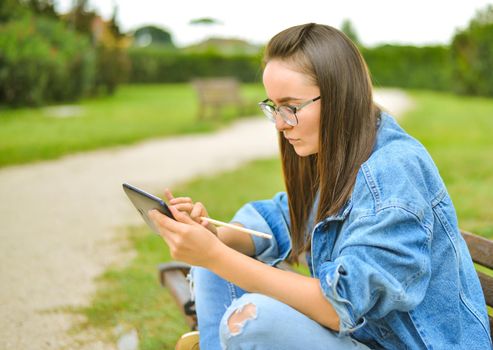 young beautiful student girl is learning outdoor. High quality photo