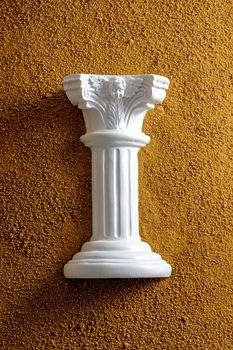 White antique column in yellow sand. Creative minimal history and archeology concept.