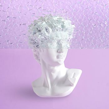 Bust of a statue of David on a purple background with fluted glass and part of the head is hidden. Contemporary minimal vaporwave concept.