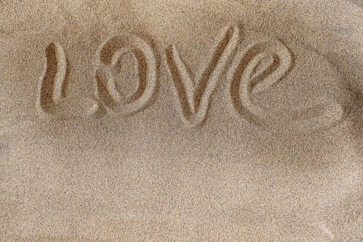 Love. Words written in beach sand background. Copy space